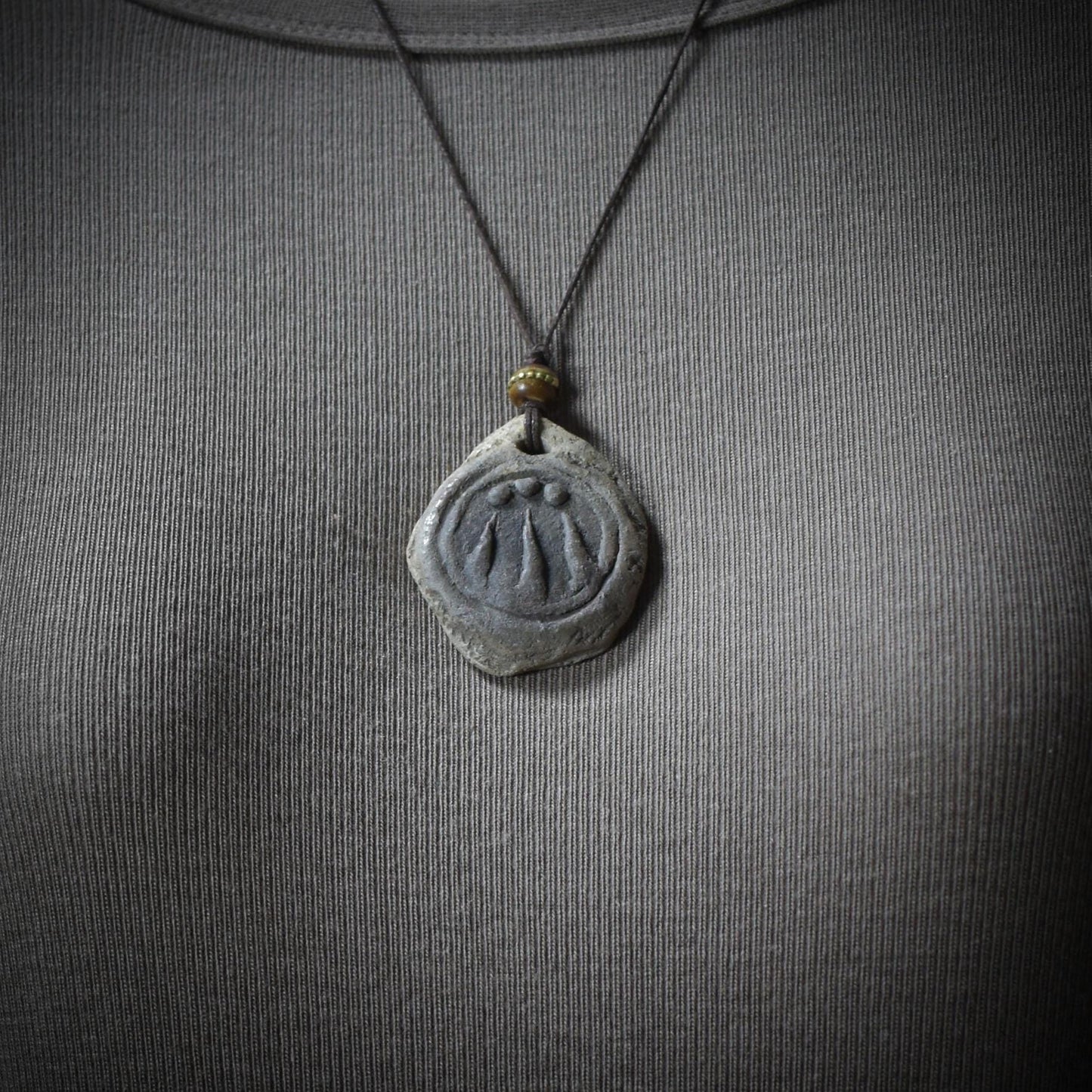 Handgefertigter Awen-Anhänger aus traditionell gebranntem Ton mit rustikalem Leder- oder Baumwollband