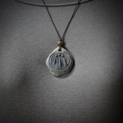 Handgefertigter Awen-Anhänger aus traditionell gebranntem Ton mit rustikalem Leder- oder Baumwollband