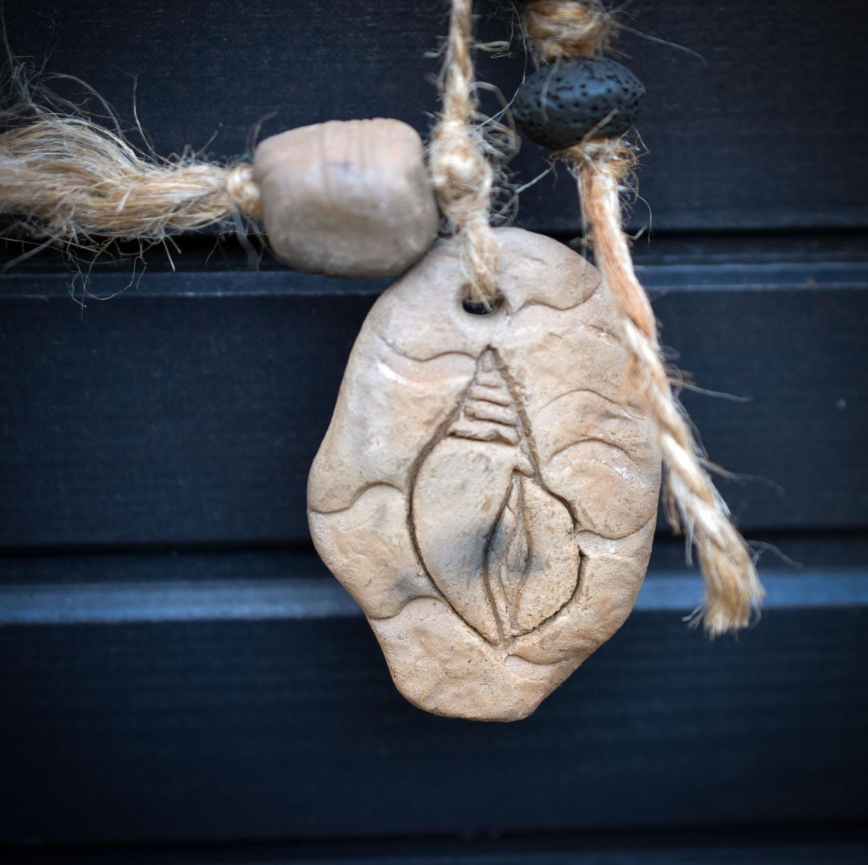 Goddess Litha Wanddeko aus Rauchbrand-Ton – archaische Sommergöttin an Holzast mit Muschelamulett & Lavaperlen HEX034