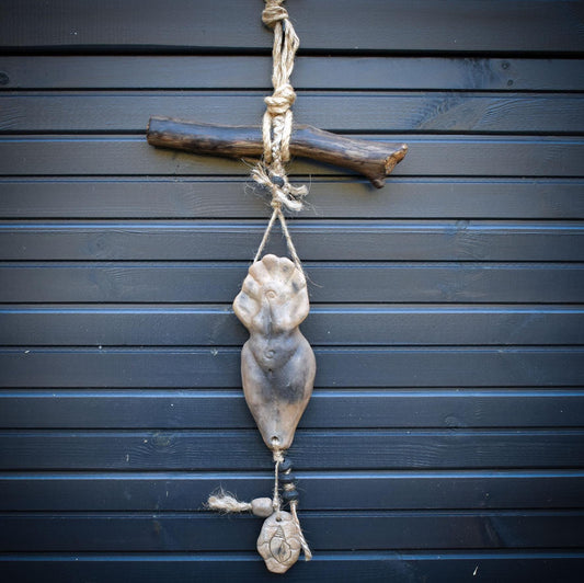 Goddess Litha Wanddeko aus Rauchbrand-Ton – archaische Sommergöttin an Holzast mit Muschelamulett & Lavaperlen HEX034