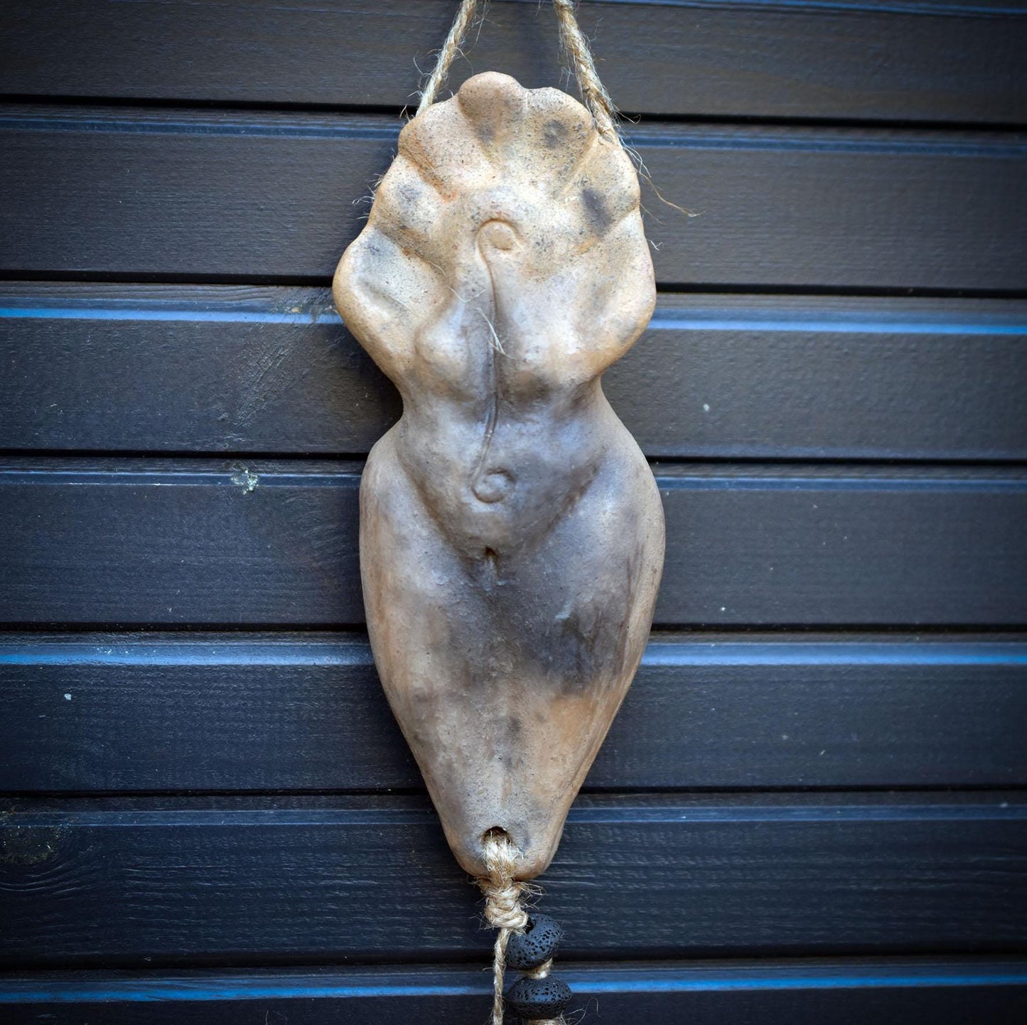 Goddess Litha Wanddeko aus Rauchbrand-Ton – archaische Sommergöttin an Holzast mit Muschelamulett & Lavaperlen HEX034