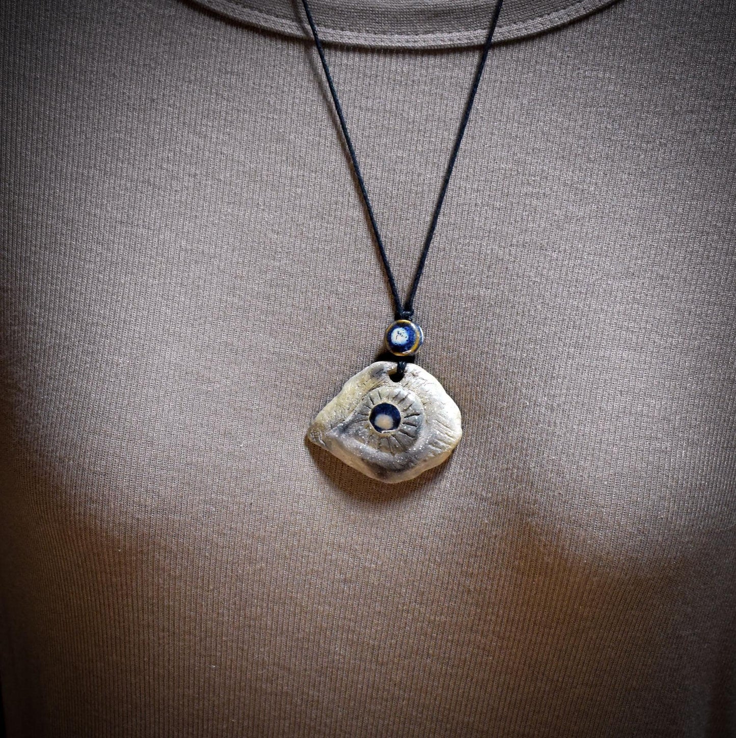 Amulett Auge mit Keramikinlay, Glücksbringer aus Rauchbrandton, Spiritueller Schmuck an Baumwollband, Archaischer Talisman Unikat AMU083